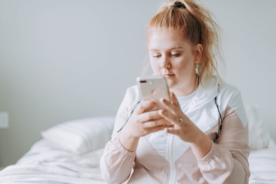 A woman sitting on the bed, with gold for 8
